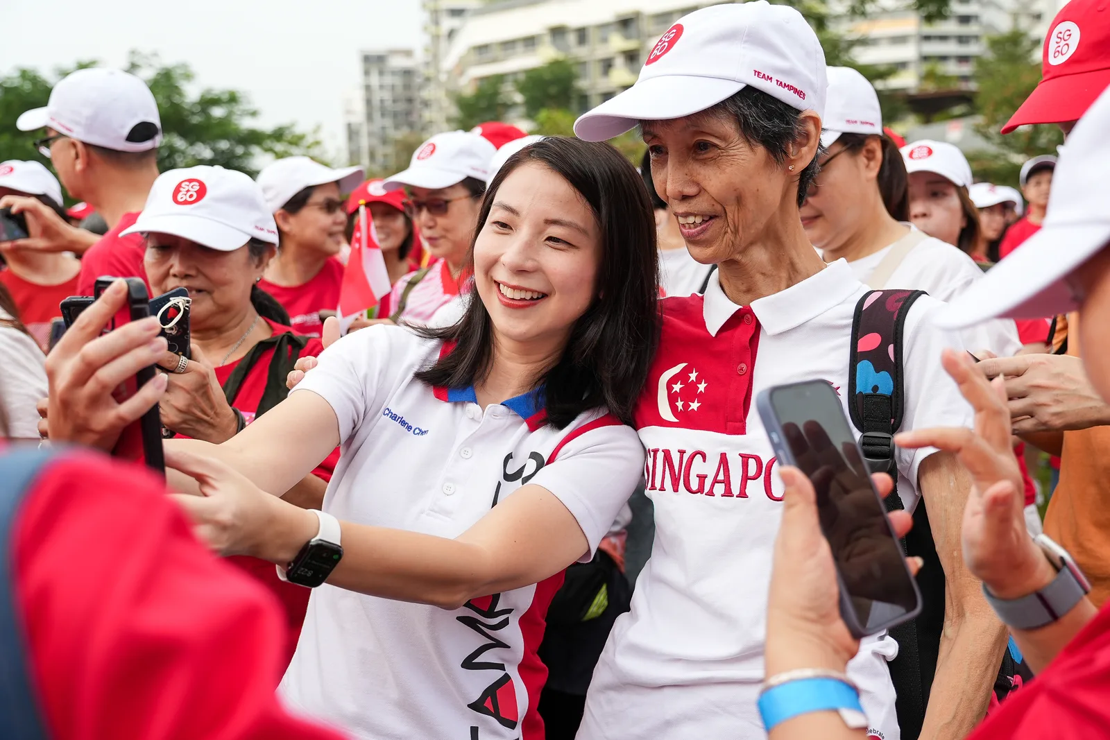 Participants waving Singapore flags at a national community celebration