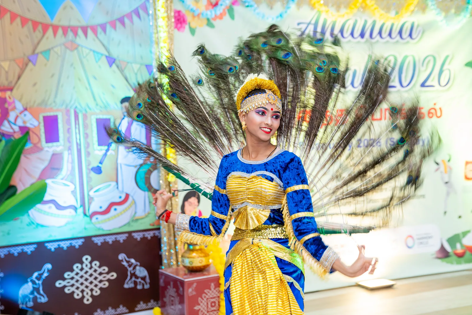 Dancer in an elaborate peacock costume performing at a cultural festival
