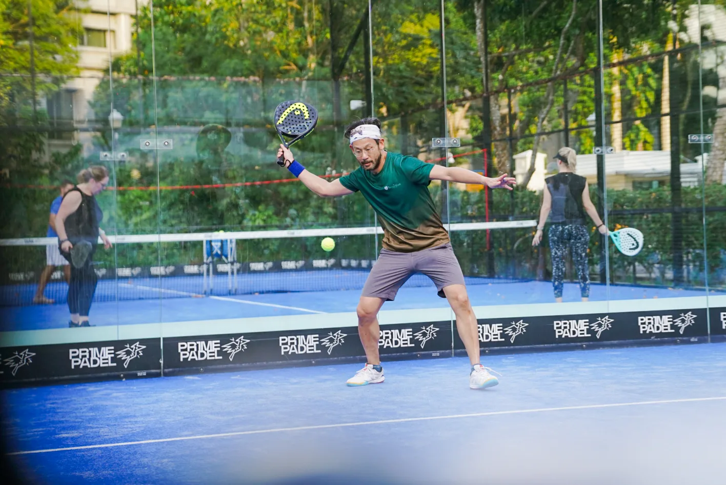 Padel player stretching for a shot during a corporate sports event