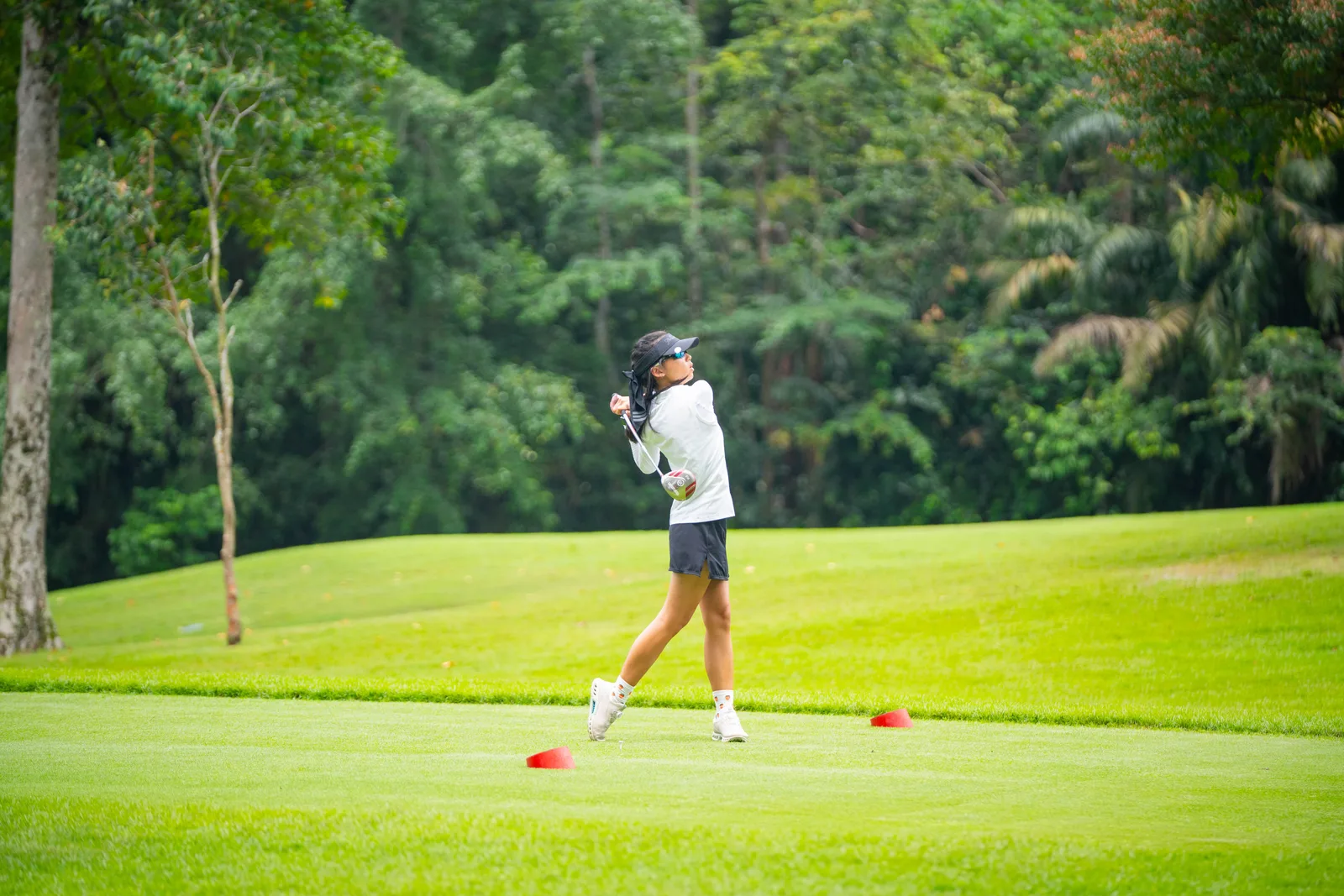 Golfer mid-swing on a fairway during a corporate golf day in Singapore