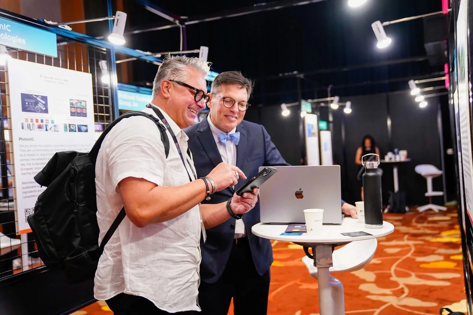 Exhibitor demonstrating a product to a delegate at a trade show booth