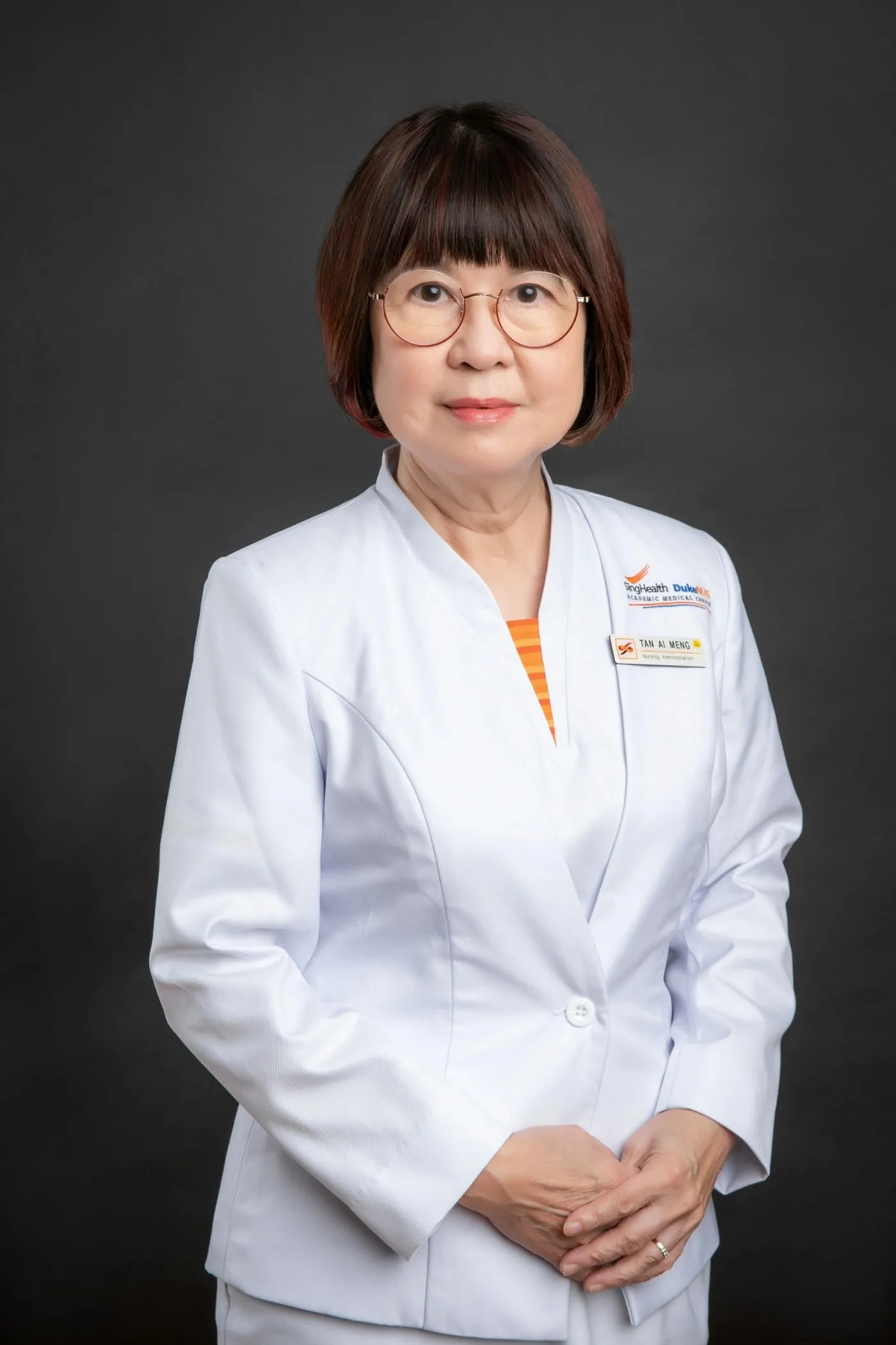 Corporate headshot of an executive in a white suit